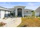 Front entryway with arched door and updated landscaping with white gravel and mature plants at 8702 Pinafore Dr, New Port Richey, FL 34653