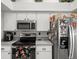 This kitchen has stainless appliances, sleek design, and is adjacent to a pantry or storage area at 8702 Pinafore Dr, New Port Richey, FL 34653