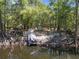 Scenic backyard featuring a boat by the water, Adirondack chairs, and a deck, perfect for outdoor living and recreation at 9019 Stone Dr, Webster, FL 33597