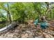 Picturesque backyard with a fire pit, Adirondack chairs, and a boat beside a tranquil waterfront, ideal for outdoor fun at 9019 Stone Dr, Webster, FL 33597