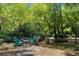 Tranquil backyard setup with Adirondack chairs around a fire pit and a wooded deck, perfect for outdoor relaxation at 9019 Stone Dr, Webster, FL 33597