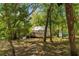 Serene backyard featuring a greenhouse with a stone pathway and surrounding lush greenery, ideal for gardening enthusiasts at 9019 Stone Dr, Webster, FL 33597