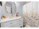 Updated bathroom features a vanity with gold hardware and a shower with leaf-patterned curtain at 9019 Stone Dr, Webster, FL 33597
