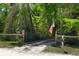 Gated property entrance featuring an American flag, solar light, and wooded surroundings at 9019 Stone Dr, Webster, FL 33597