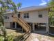 Charming raised home featuring wood stairs, neutral siding, and spacious ground-level covered parking and recreational area at 9019 Stone Dr, Webster, FL 33597