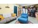 Inviting multipurpose room with sleeper sofa, blue armchair, and storage shelving at 9019 Stone Dr, Webster, FL 33597