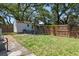 Fenced backyard features a shed and a blue seating arrangement around a fire pit, perfect for outdoor gatherings at 906 E Patterson St, Tampa, FL 33604