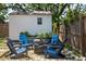 Backyard shed with a seating area featuring blue Adirondack chairs at 906 E Patterson St, Tampa, FL 33604