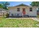 Cozy backyard with a small patio, a well-maintained lawn, and a charming peach-colored door at 906 E Patterson St, Tampa, FL 33604