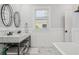 Bright bathroom features a marble countertop, modern fixtures, and stylish black and white patterned tile at 906 E Patterson St, Tampa, FL 33604