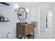 Well-lit bathroom with a wood vanity, decorative mirror, and patterned tile flooring at 906 E Patterson St, Tampa, FL 33604