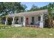 Inviting single-story home with a covered porch, porch swing and vibrant landscaping at 906 E Patterson St, Tampa, FL 33604