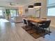 Bright dining area with modern lighting, wood table, and an open view to the living room at 9943 Campanula Ct, Land O Lakes, FL 34637