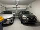 Two-car garage with two parked cars and an open garage door mechanism at 9943 Campanula Ct, Land O Lakes, FL 34637