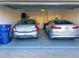 Two-car garage with two parked cars and a blue recycling bin at 9943 Campanula Ct, Land O Lakes, FL 34637