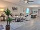 Bright living room featuring a large sofa, decorative rug, and dining area in an open concept layout at 9943 Campanula Ct, Land O Lakes, FL 34637