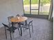 Cozy screened patio with a round wooden table and four chairs, perfect for outdoor dining at 9943 Campanula Ct, Land O Lakes, FL 34637