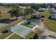 Aerial view of community amenities including a shuffle board area and a tennis court at 10029 Wellington Ave, Dade City, FL 33525