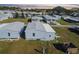 An aerial view of a charming single-Gathering home nestled in a well-maintained community under a vibrant evening sky at 10029 Wellington Ave, Dade City, FL 33525