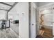 Hallway view showcasing modern flooring, living area, and access to bathroom at 10029 Wellington Ave, Dade City, FL 33525