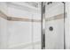 Tiled shower stall with glass doors and a shower head at 10029 Wellington Ave, Dade City, FL 33525