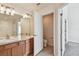 Bathroom featuring double sinks with wood cabinets and tile flooring, adjacent to open toilet room at 10135 Post Harvest Dr, Riverview, FL 33578