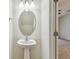 Bathroom featuring a pedestal sink, oval mirror, and modern lighting at 10135 Post Harvest Dr, Riverview, FL 33578