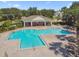 Beautiful community pool with seating area and pool house surrounded by mature landscaping at 10135 Post Harvest Dr, Riverview, FL 33578