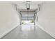 Clean garage with open door and view of the driveway and front yard at 10135 Post Harvest Dr, Riverview, FL 33578