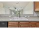 Modern kitchen sink with neutral countertop and views into the bright living area at 10135 Post Harvest Dr, Riverview, FL 33578