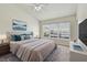 Cozy bedroom with plush bedding, a ceiling fan, and a large window at 10135 Post Harvest Dr, Riverview, FL 33578