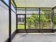 A screened-in patio featuring a concrete floor, a view of the lawn, and black framing at 10135 Post Harvest Dr, Riverview, FL 33578