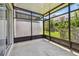 The screened-in patio features concrete floors, black framing, and lawn views at 10135 Post Harvest Dr, Riverview, FL 33578