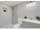 Bathroom featuring walk-in shower with gray backsplash, gray vanity, and decorative plant at 10218 Lola St, Tampa, FL 33612