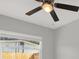 Bedroom featuring a ceiling fan, a window overlooking a wood fence, and gray walls at 10218 Lola St, Tampa, FL 33612