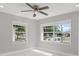 Cozy bedroom featuring ample natural light from two windows and a modern ceiling fan at 10218 Lola St, Tampa, FL 33612