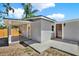 The exterior is painted gray with a brown wood door, a porch, and a concrete walkway at 10218 Lola St, Tampa, FL 33612
