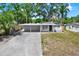 Charming single-story home with a convenient carport and well-manicured lawn, creating a welcoming curb appeal at 10218 Lola St, Tampa, FL 33612