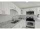 Modern kitchen featuring white cabinets, stainless steel appliances, and granite countertops at 10218 Lola St, Tampa, FL 33612
