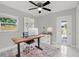Bright office space with a modern desk, a comfortable chair, and a door to the backyard at 10218 Lola St, Tampa, FL 33612