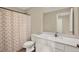 Clean bathroom featuring a white vanity, toilet, and a shower with a patterned curtain at 11443 Cay Spruce Way, San Antonio, FL 33576