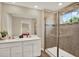 Bright bathroom with double sinks, modern cabinets, and a glass-enclosed shower with a window at 11443 Cay Spruce Way, San Antonio, FL 33576
