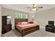A comfortable bedroom features a wooden bed frame, a mini-fridge, and a cozy recliner at 11443 Cay Spruce Way, San Antonio, FL 33576