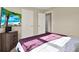 Bedroom with a purple blanket on the bed and a modern TV stand with beach view displayed at 11443 Cay Spruce Way, San Antonio, FL 33576