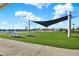Inviting community lawn area, featuring comfortable Adirondack chairs, cornhole, and lush landscaping, perfect for gatherings at 11443 Cay Spruce Way, San Antonio, FL 33576