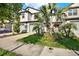 Attractive townhome with a two-car garage, beautiful palm trees, and a well-manicured lawn at 11443 Cay Spruce Way, San Antonio, FL 33576