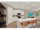 Bright, modern kitchen with white cabinets, a large island, stainless steel appliances, and contemporary bar seating at 11443 Cay Spruce Way, San Antonio, FL 33576