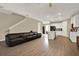 Open-concept living room area with an extra-long couch, wood floors, and views of the kitchen at 11443 Cay Spruce Way, San Antonio, FL 33576