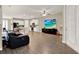 Spacious living room with modern flooring open to a white kitchen and large screen TV at 11443 Cay Spruce Way, San Antonio, FL 33576