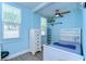Comfortable bedroom featuring a ceiling fan, natural light, and a crisp, blue color scheme at 1240 Georgia Ave, Dunedin, FL 34698